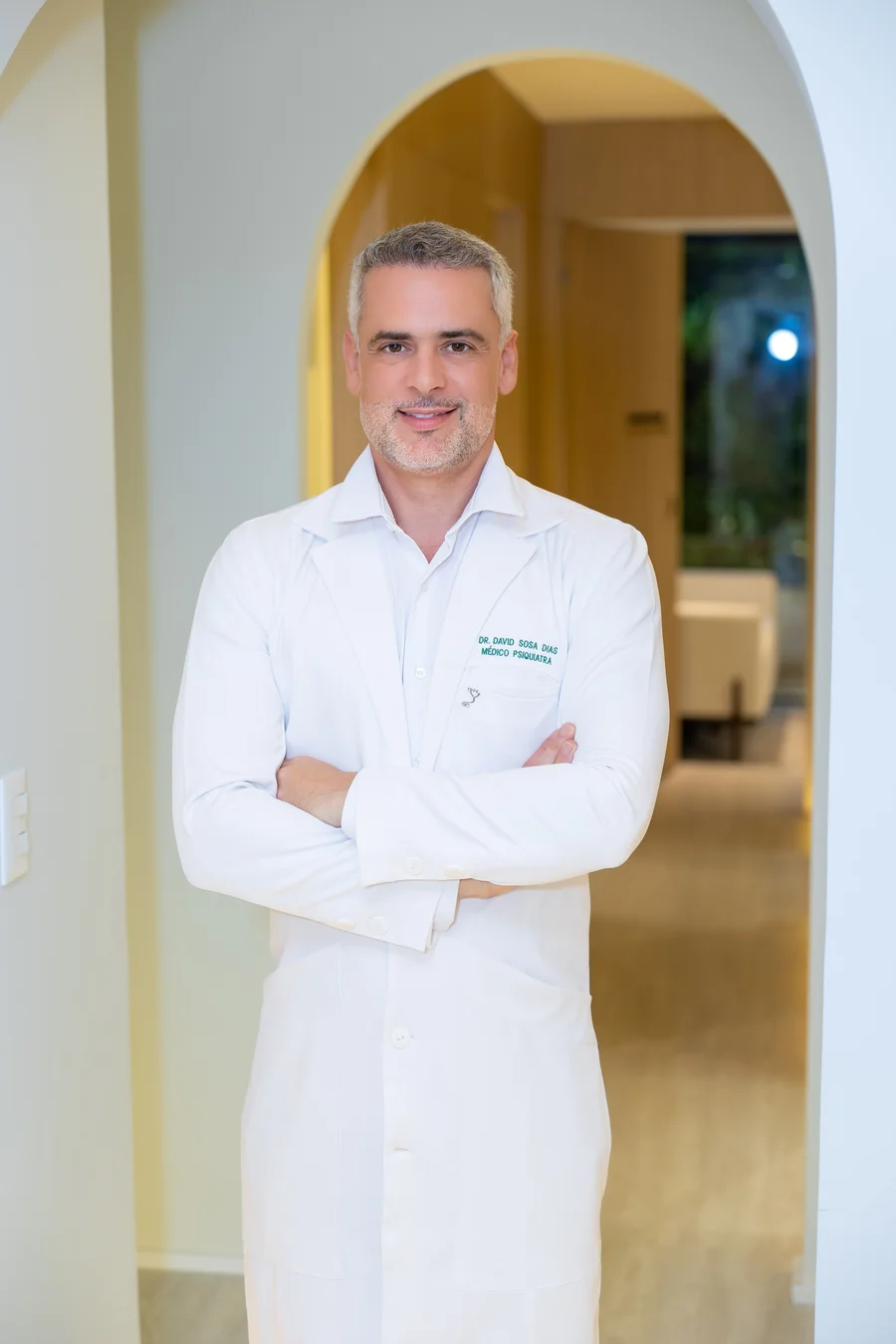 Dr. David Sosa Dias em pé no jaleco — psiquiatra do Instituto InMind, Botafogo, Rio de Janeiro